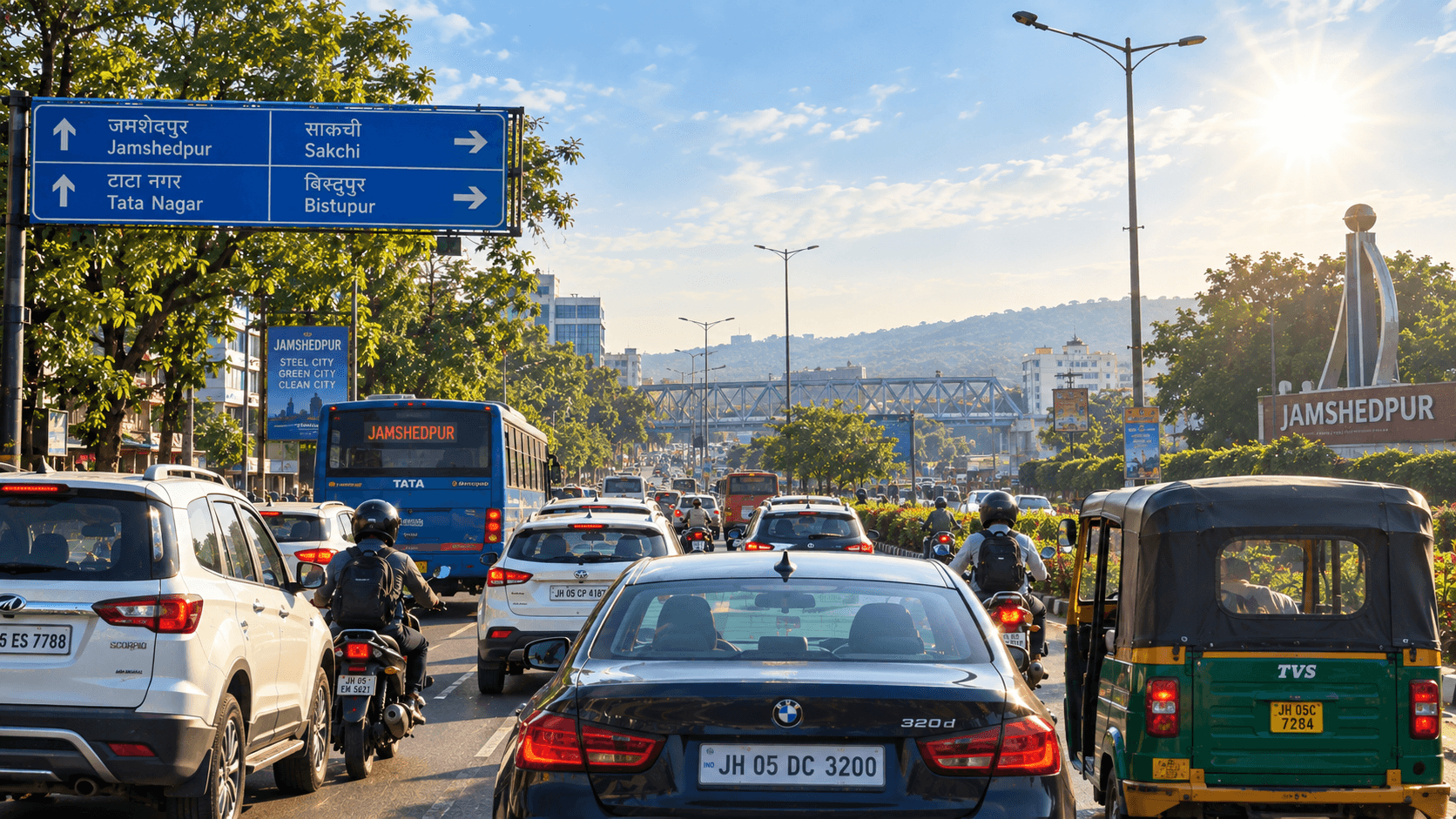 Cars in daytime traffic on a Jamshedpur road under bright sun